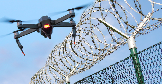 Drone monitoring barbed wire fence on state border or restricted area (684x355 px)