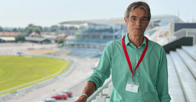 man standing on a viewing platform with panoramic background