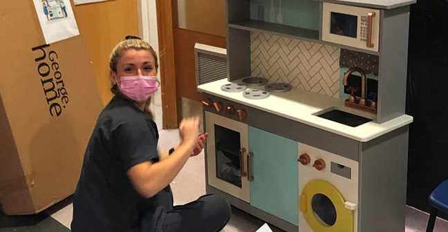 Student with a toy kitchen