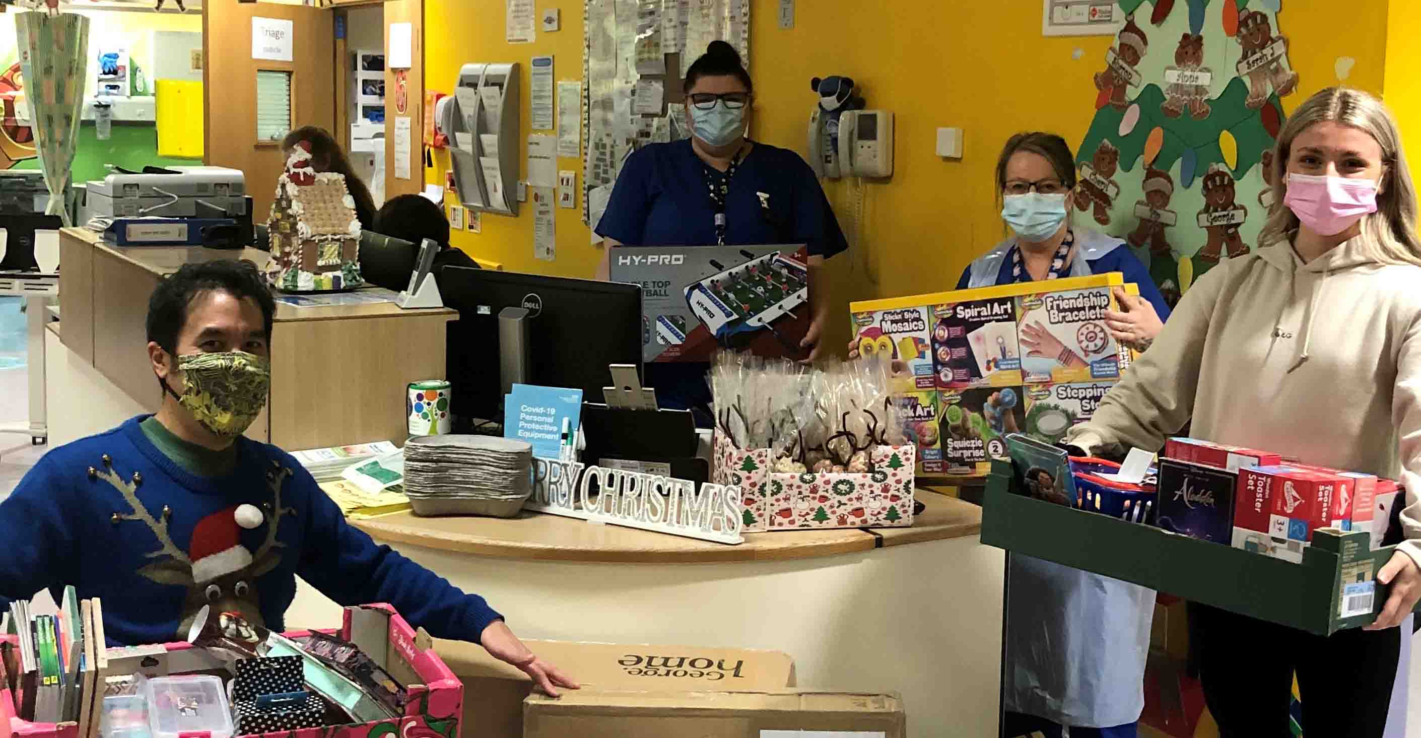 4 people wearing masks and holding toys indoors