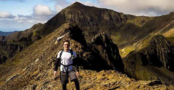 Student on a mountain looking at camera