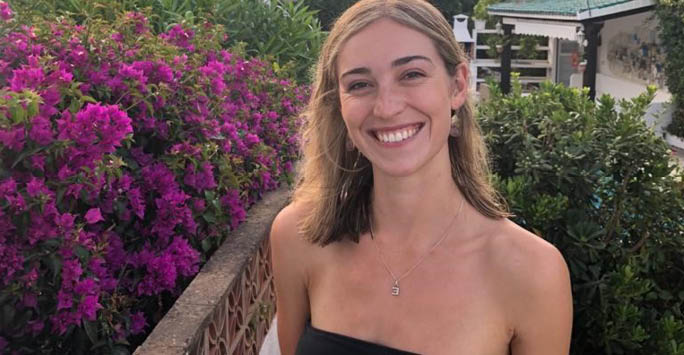 smiling woman with flowers in the background