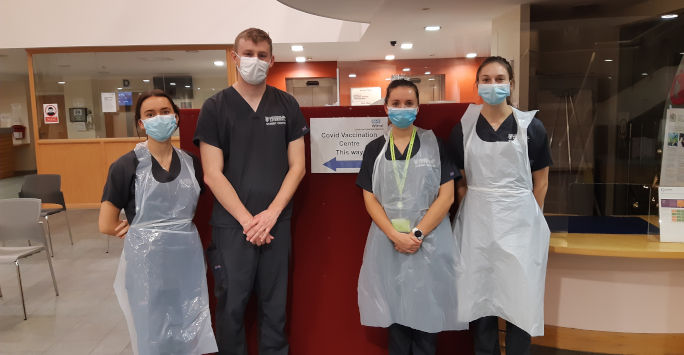  students standing in a line wearing PPE