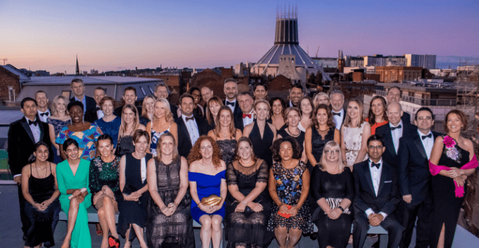 Group of people on rooftop with cathedral in the background