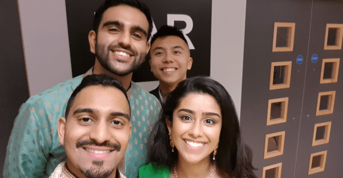 Group of 4 friends smiling to the camera