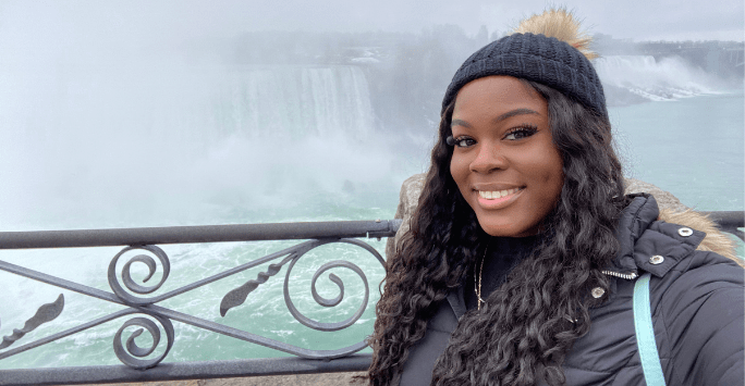 student smiling in front of Niagra Falls