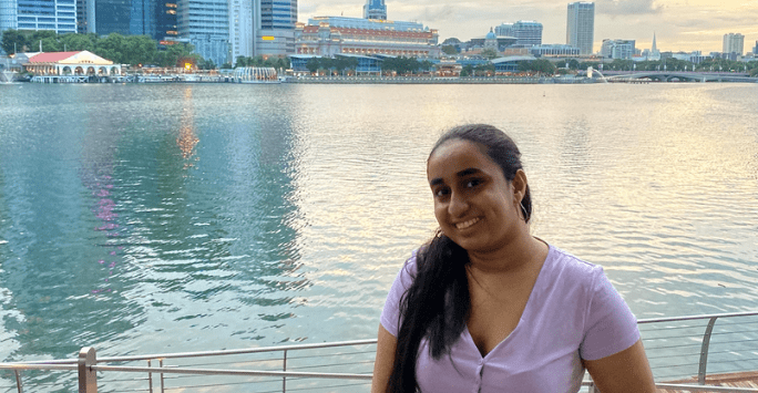 Smiling student with lake and skyscrapers in the background