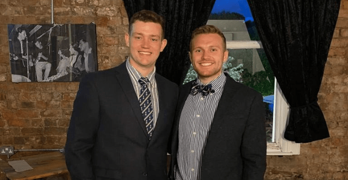 two men dressed in suits and ties and bow ties