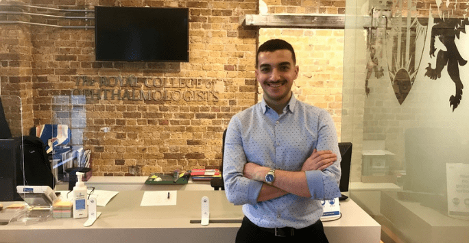 smiling student in front of a reception area