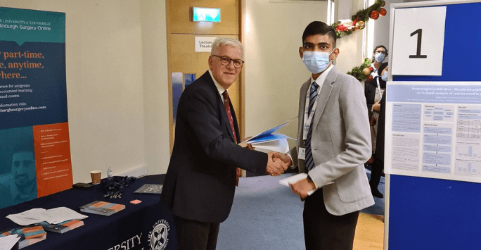 student shakes hands with a man congratulating him