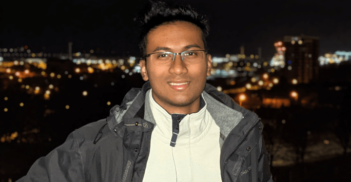 man smiling to camera with night sky backdrop