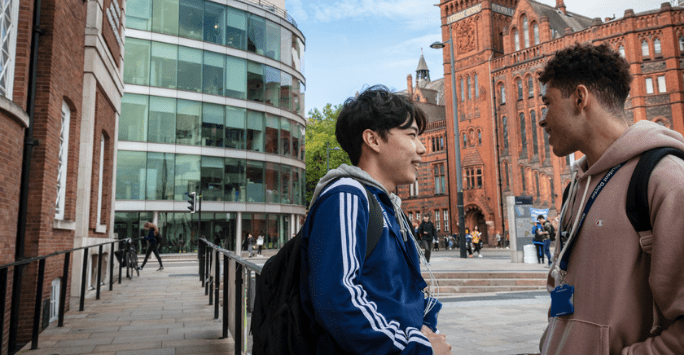 two students have a chat on university campus