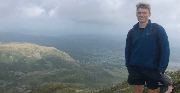 man standing on mountain top with panoramic view