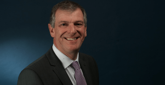 man in suit and tie smiles to camera