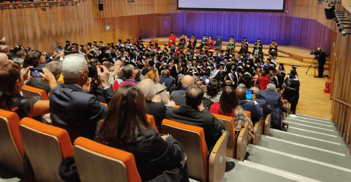 graduates clap their loved ones