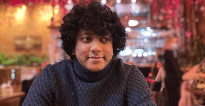 man in restaurant with floral details overhead