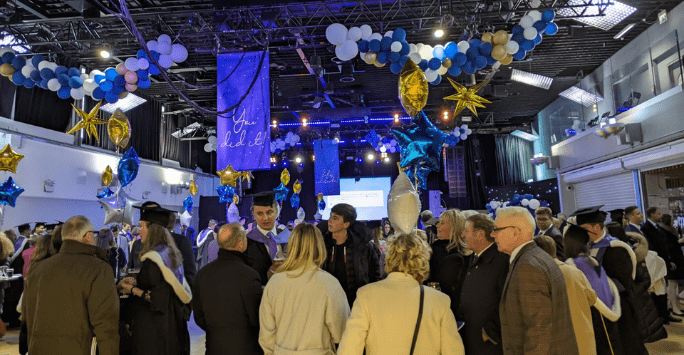 Graduates and guests celebrate at a reception