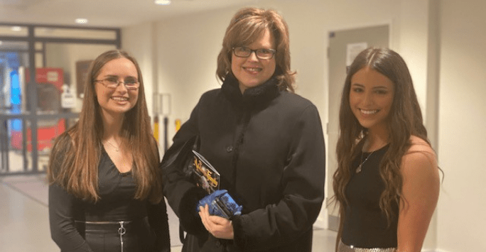 three women smile to the camera