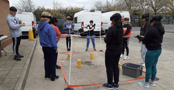 students participate in an activity lifting blocks blindfolded