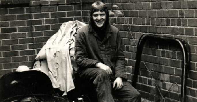 black and white photo of man sitting on homemade beach buggy