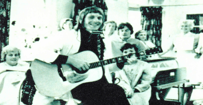 doctor plays guitar on hospital ward in the 1970s