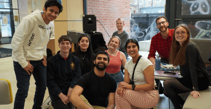 a group of students pose for a photo in front of a piano