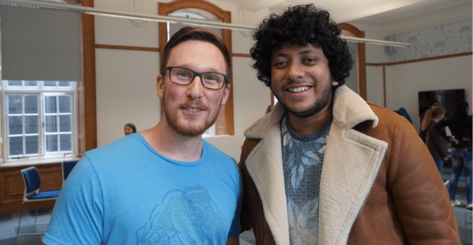 two students smile to the camera