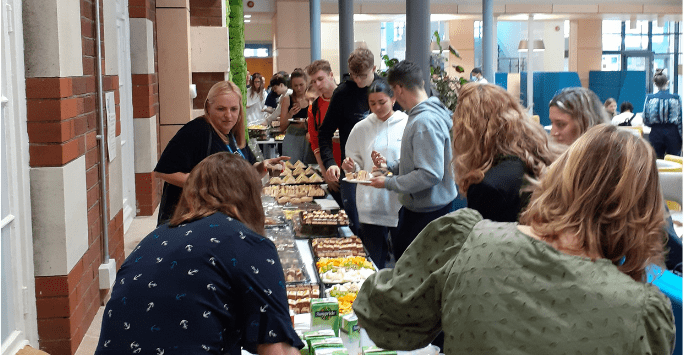 people pick up food from a buffet