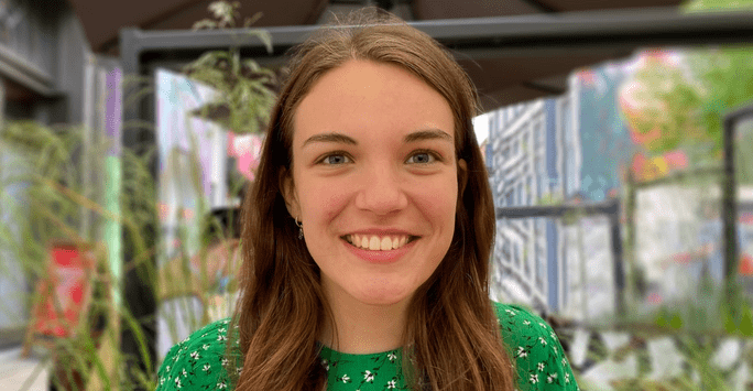 woman in green dress smiles to camera