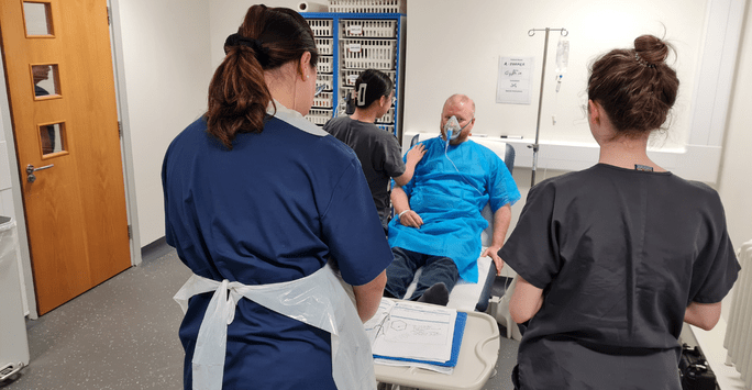 student doctors work with a simulated patient actor in a clinical scenario