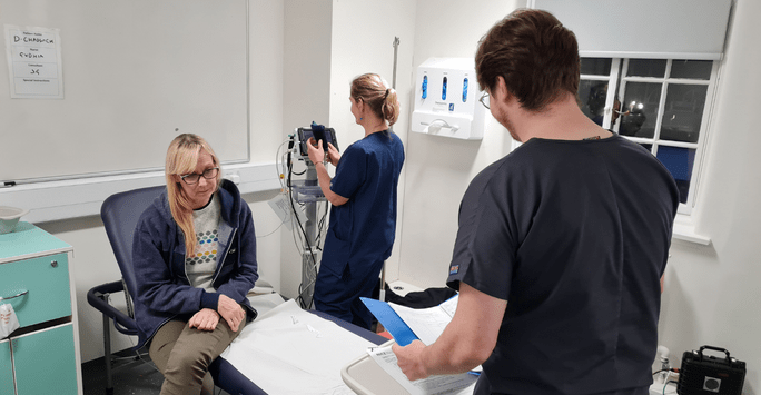 student doctors work with a simulated patient actor in a clinical scenario