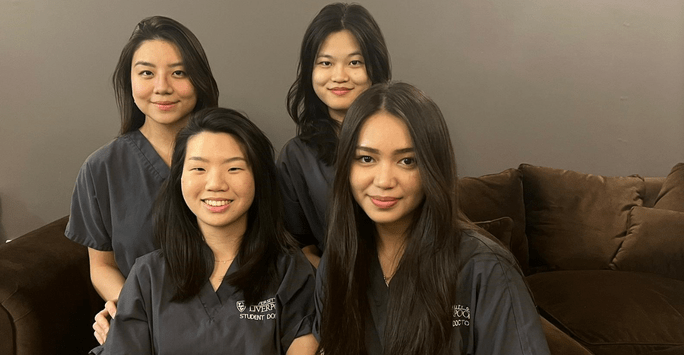 four student doctors in grey scrubs