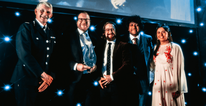 presenters and winners pose with trophy at award ceremony