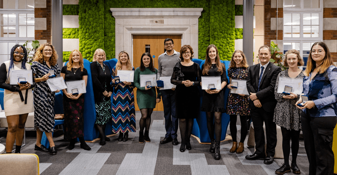 a row of prize winners with their certificates and medals