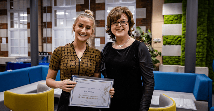 Dean of the School poses with a student prize winner