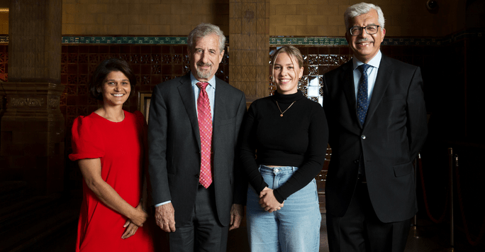 student poses with professors at awards event