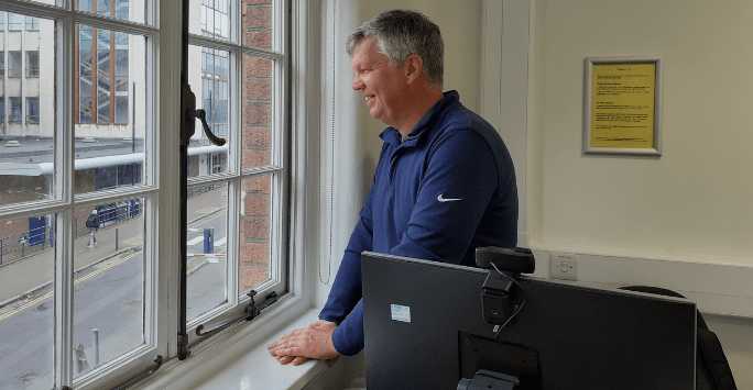 man looks out of classroom window