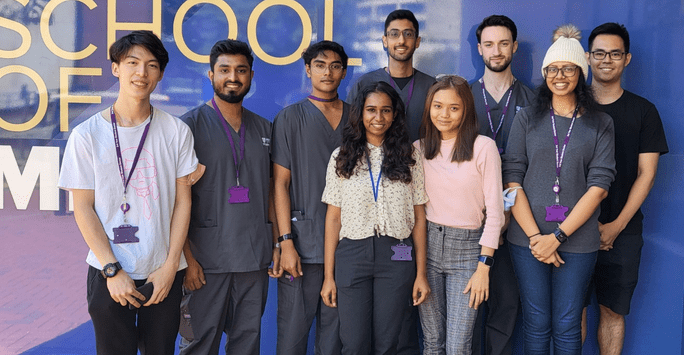 group of students, some wearing scrubs