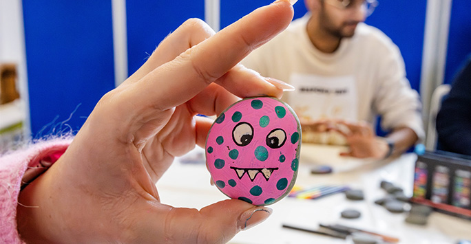 Pebble painted pink with a face