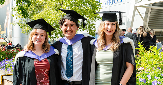 Graduates smiling outside