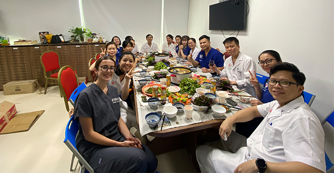 Student and staff celebrate birthdays at a table laid with local delicacies