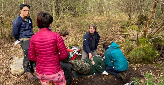 Students enacting an emergency scenario in the forest