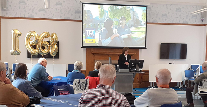 The Dean of the School of Medicine giving a welcome talk to alumni