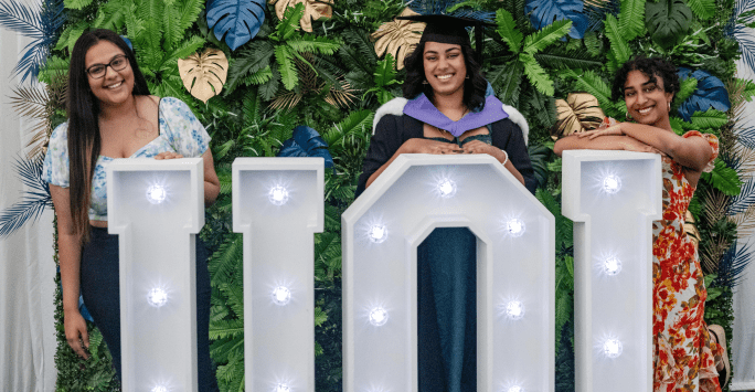 graduates pose with UOL letters