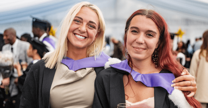 graduates pose in gowns