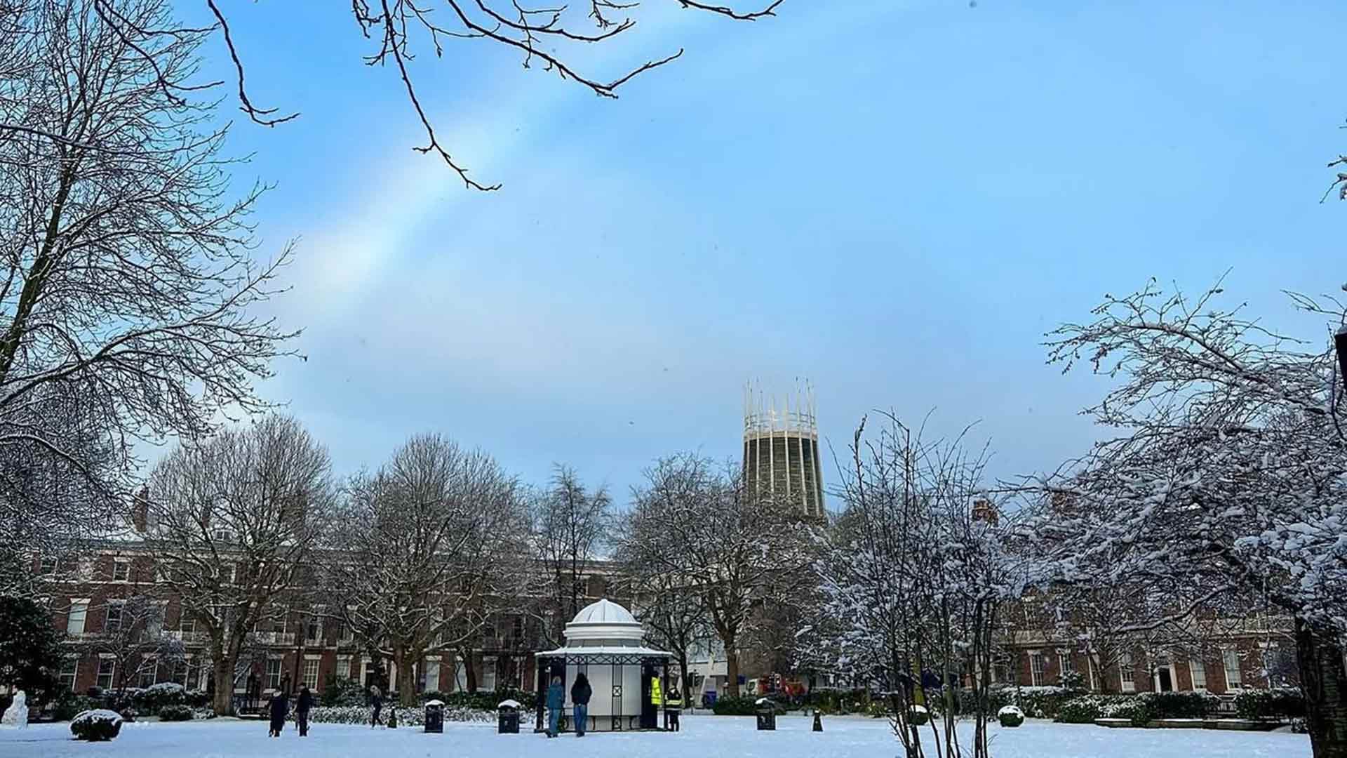 snowy park with rainbow sky