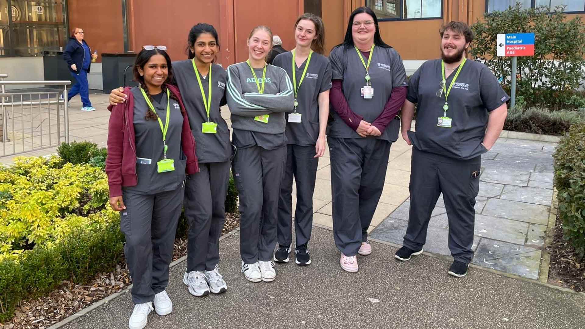 group of student doctors in scrubs outside hospital