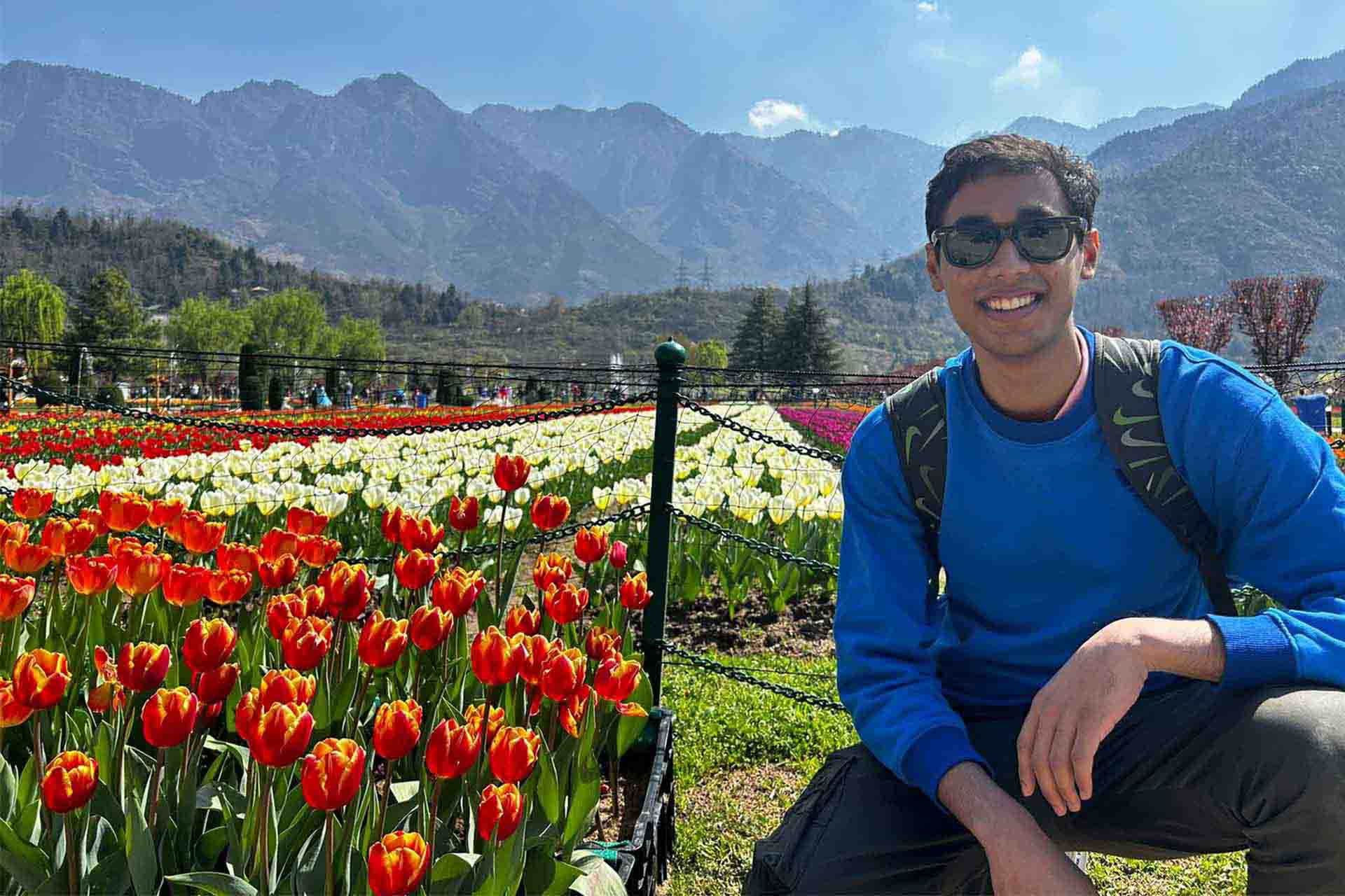 a man in sunglasses in a field of tulips