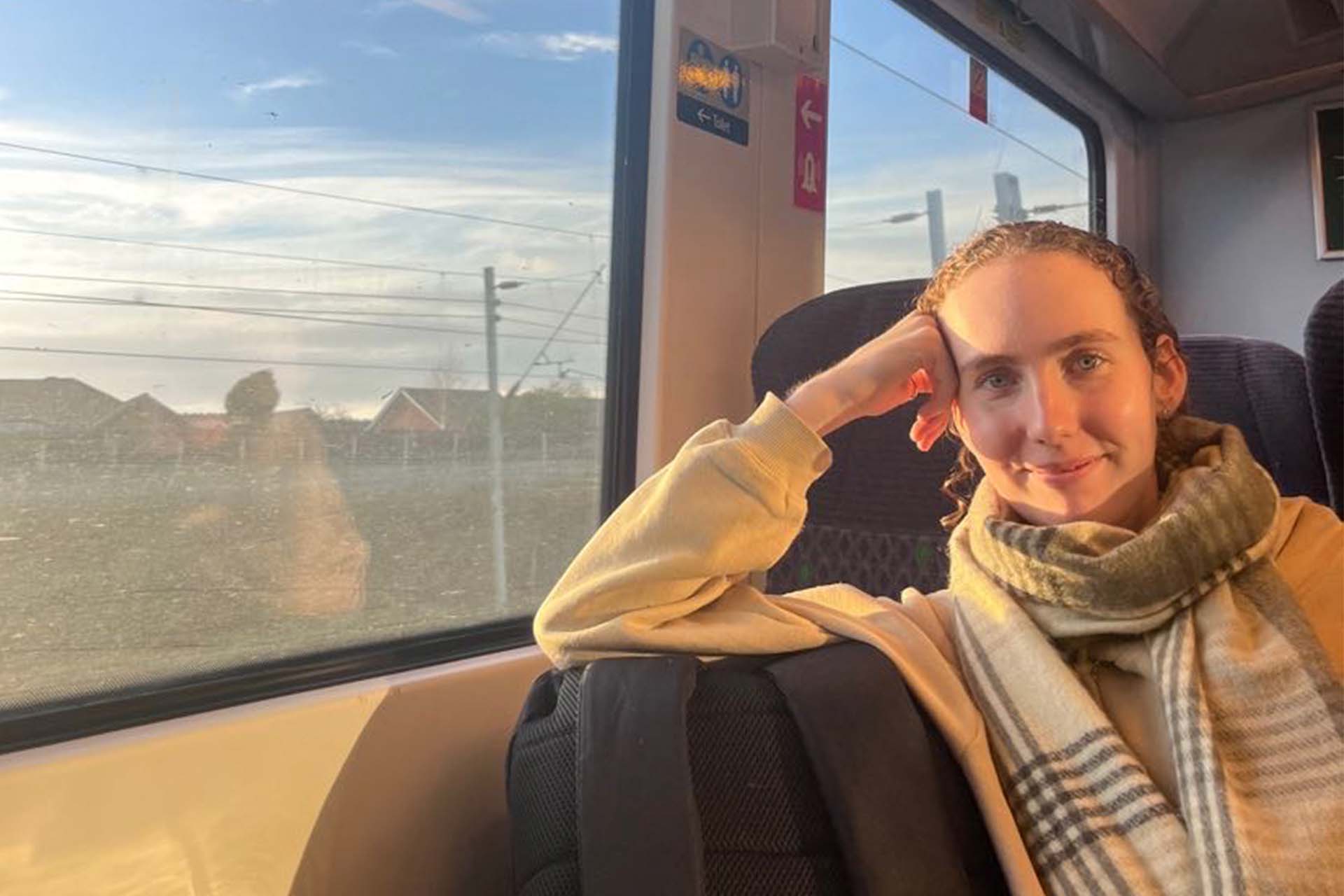 a woman on a train with sunlight streaming through the window