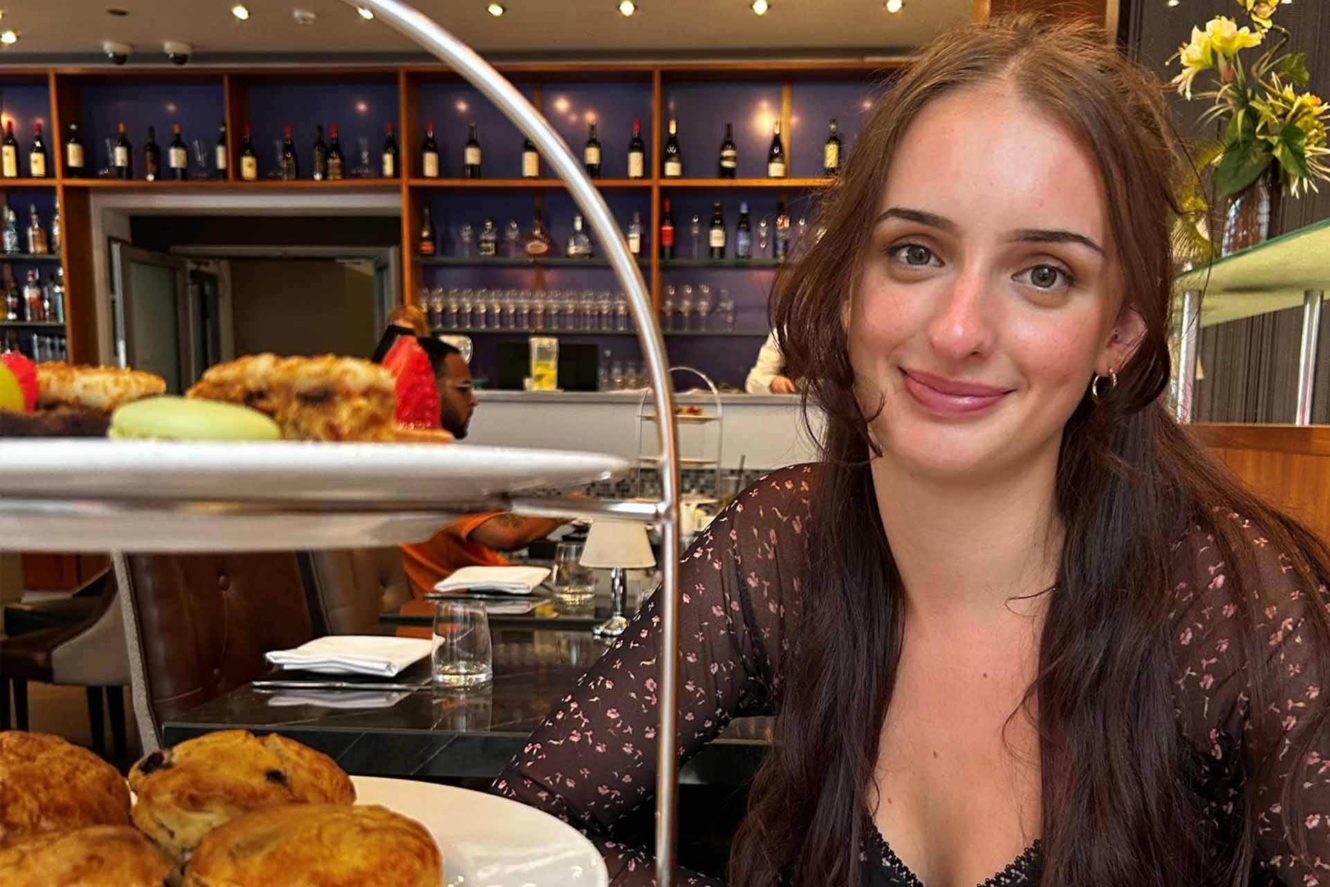 woman smiling to camera in an afternoon tea setting